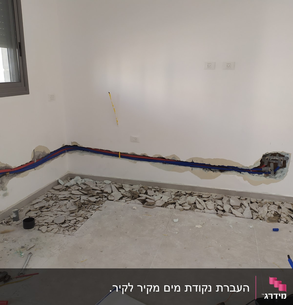 קירות פתוחים עם צינורות צבעוניים וכלי עבודה על הרצפה